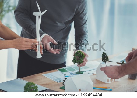 General planning. Close up of male and female hands carrying models and arranging them on surface Royalty-Free Stock Photo #1169454484