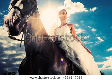 Young Bride in wedding dress riding a horse, backlit picture, dreamy mood