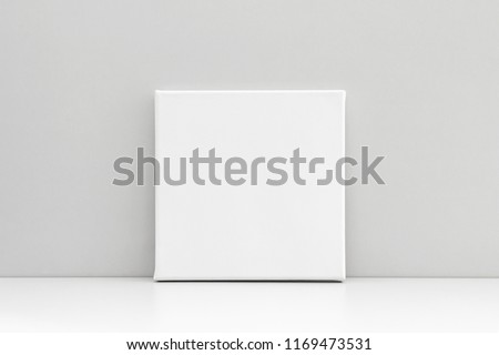 White empty square canvas on neutral gray background. Mock up poster, canvas template. Royalty-Free Stock Photo #1169473531