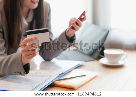 Women wear suits Credit card holders are shopping online by phone in a coffee shop.