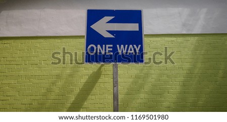 One way signage with green and white backdrop