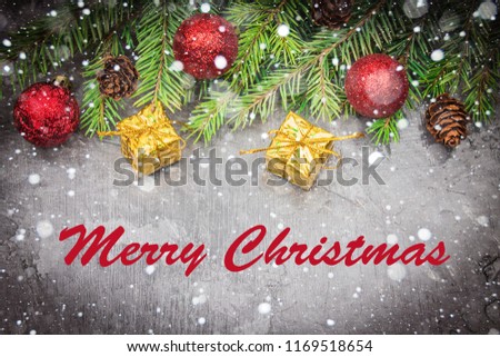 Merry Christmas. Christmas tree branch with a toy on a gray background