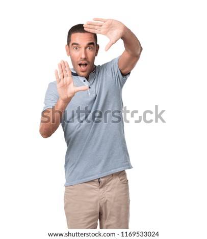 Concept of a surprised young man trying to focus to take a photo with his hands