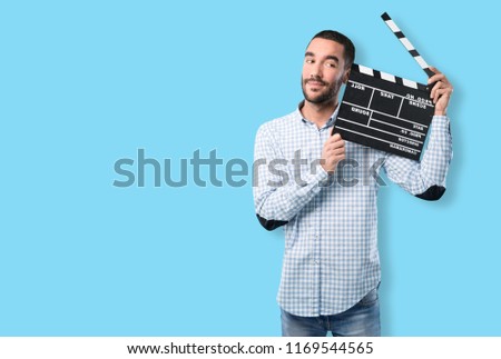 Young man with a vintage camera and a clapperboard