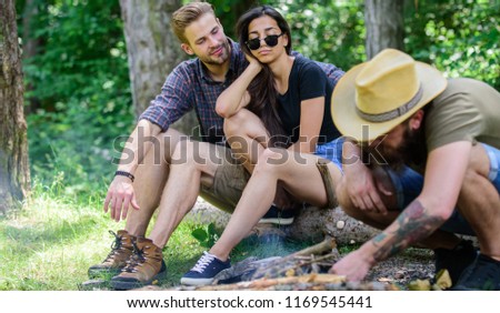 How build bonfire outdoors. Man brutal bearded hipster prepares bonfire in forest. Ultimate guide to bonfires. Camping weekend leisure. Arrange woods twigs or sticks. Company friends camping forest.