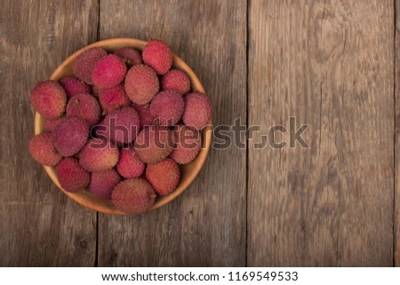 heap of Lychee in wooden plate on wooden background