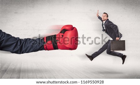 Arm with red boxing gloves hits office worker concept