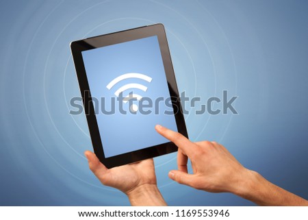 Female fingers touching tablet with wireless connection icon