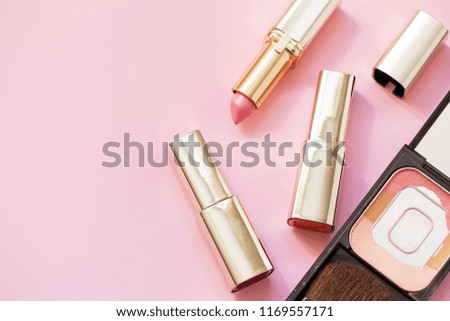 Set of decorative cosmetics on pink  background. Blush and lipsticks.  Top view. Copyspace