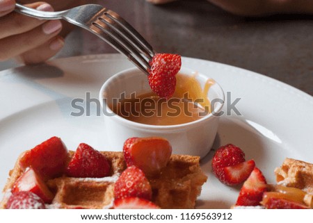 delicious dessert with strawberries and waffles in a white plate