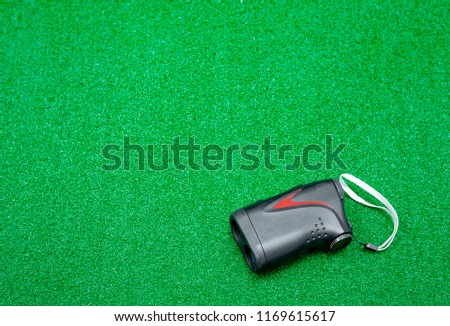 Range​ finder for golf  placed on artificial grass.