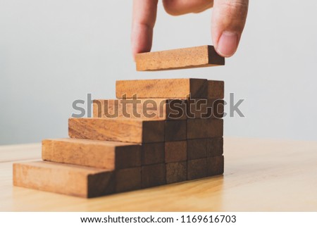 Hand arranging wood block stacking as step stair. Ladder career path concept for business growth success process Royalty-Free Stock Photo #1169616703