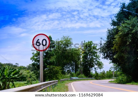 Speed Limited (60km/ h) warning sign against a background of blue sky in Thailand.