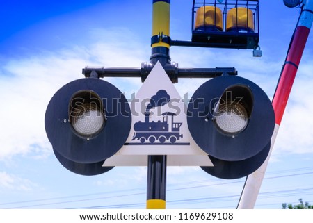 Train warning sign, railway crossing against a background of blue sky in Thailand