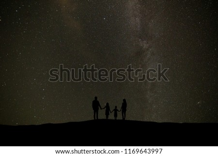 The family standing on the background of a sky with stars