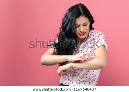 Young woman scratching her itchy arm. Skin problem. Royalty-Free Stock Photo #1169648437