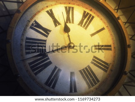 Old clock close up lit with cold and warm lights