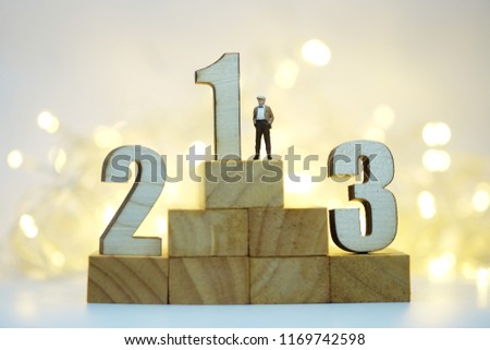 Miniature people : Businessmen standing with wooden number of 1,2,3 to be the first , Picture use for business competition concept.