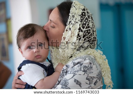 Mother in the church kisses and hugs her son
