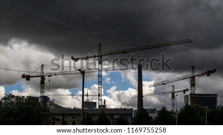 Tower cranes at work under thunderstorm in a district under construction in the suburbs of the city of Tallinn, Estonia