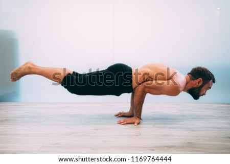 Yoga. Young man doing yoga exercise isolated on a white background. Yogi master workout on white urban studio. Yoga lifestyle healthy concept.