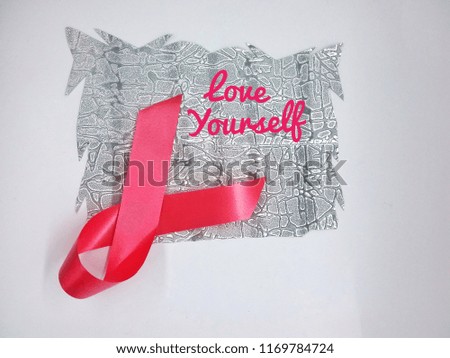 cancer awareness ribbon with 'Love yourself' words on white background.
