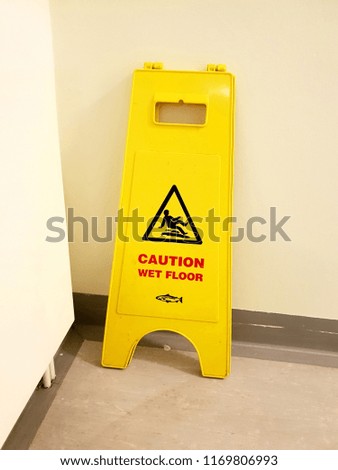 Caution wet floor sign board against wall