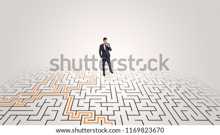 Young entrepreneur standing in a middle of a labyrinth with the solution