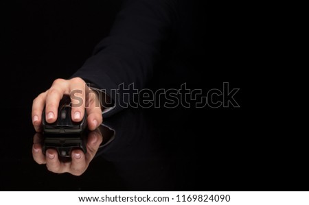 Hand using wireless mouse in a dark environment