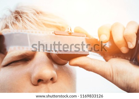 Male uses the Old vintage 35mm film Negative Viewer to see a frames