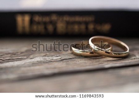 the bible is the base where upon two wedding rings rest. Wedding symbols, attributes. Holiday, celebration.