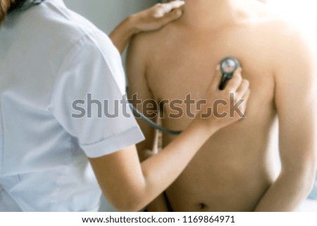 Blurry Doctor examining patient with stethoscope in hospital. Medical examination, stethoscope, medicine and therapy.