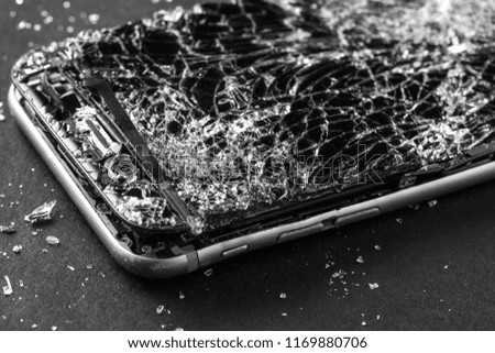 mobile phone with broken touchscreen on gray background.