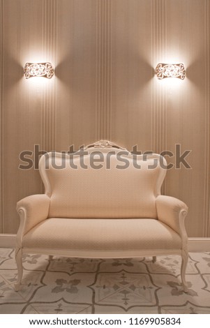 White sofa in a bright room with sconces included.