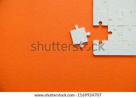 Close up jigsaw puzzle pieces on orange background,Business success concept.