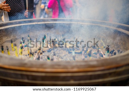 Smoke from many burning incense in giant incense burner,In front of famous Buddhist temple Senso-ji in Asakusa, Japan.