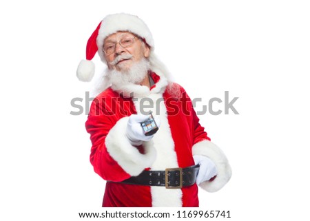 Christmas. Santa Claus in white gloves holding a TV remote control. Browse Christmas TV listings, select the channel. Isolated on white background.