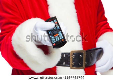 Christmas. Close-up. Santa Claus in white gloves holding the TV remote control. Browse Christmas TV listings, select the channel. Isolated on white background.