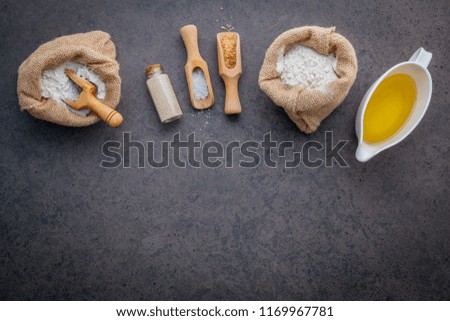 The ingredients for homemade pizza dough on dark stone background.