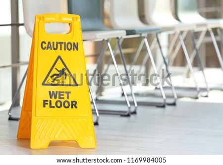 Safety sign with phrase Caution wet floor, indoors. Cleaning service