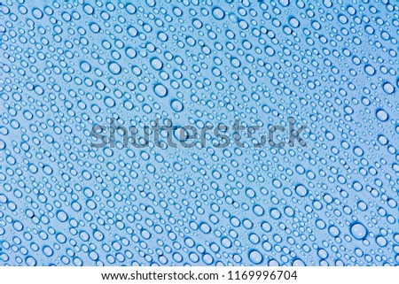 Close up water drops on dark blue tone background. Abstarct sky blue wet texture with bubbles on window glass surface. Raindrop, Realistic pure water droplets condensed for creative banner design