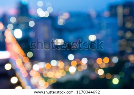 Abstract urban night light bokeh defocused of city and the office building. City and tower blurred background on twilight color sky. Night light of real estate as concept.