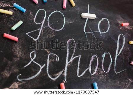 Motivation text keep calm and go to school on school black chalkboard with school accessories