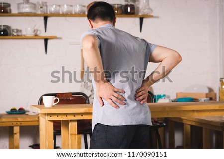 Back pain, kidney inflammation, man suffering from backache at home Royalty-Free Stock Photo #1170090151