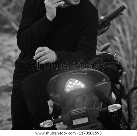 Man sitting on a bike talking over a cellphone isolated unique blurry photo