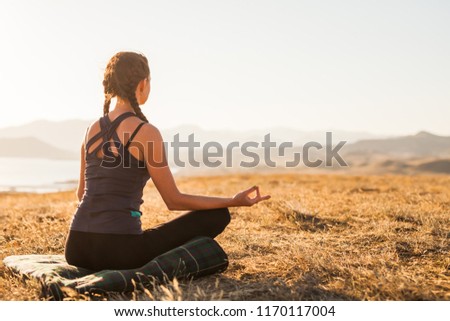 girl practicing yoga in the mountains by the sea