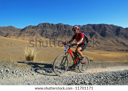 Mountain biker racing on old road in desert