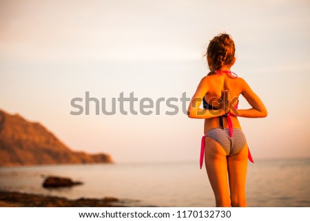 child practicing yoga in the mountains by the sea