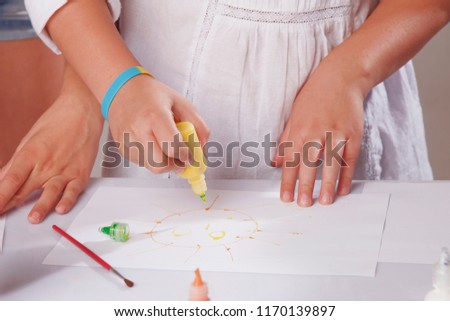 beautiful little child girl draws a picture paints (talent, creativity concept)