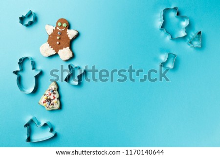 Christmas cookies various shape cutter on blue background with copy space. Top view. Flat lay. Trendy colorful photo. Minimal style with colorful paper backdrop. Christmas concept.